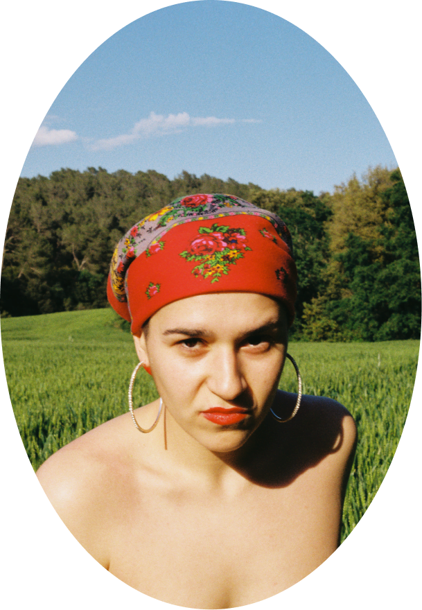 Portretul artistei rap Xeno Bitch. El este înfățișat într-o vedere frontală, cu o eșarfă roșie pe cap.